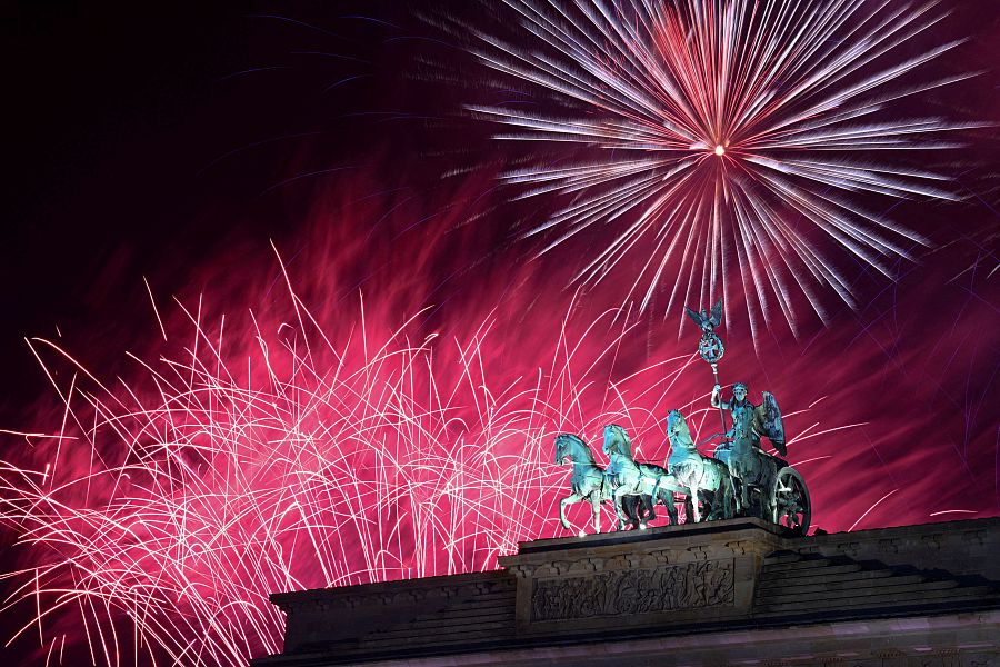 Fuegos artificiales iluminan la escultura Quadriga en lo alto de la Puerta de Brandeburgo, Berlín, Alemania