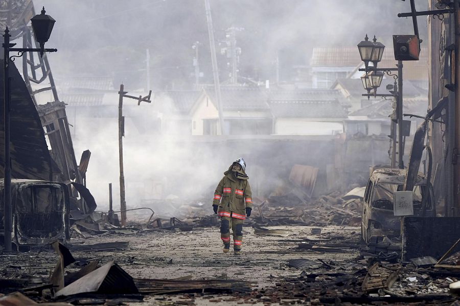 Un bombero camina entre los escombros de un mercado incendiado en Wajima, Ishikawa