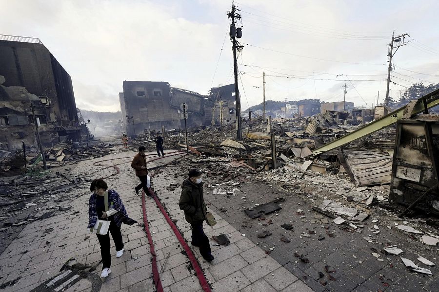 Varias personas caminan junto a los escombros que ha dejado el terremoto en Wajima, Ishiwaka