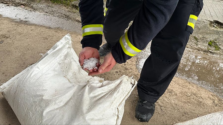 Un operario de emergencias de Ribeira muestra los pélets de plástico