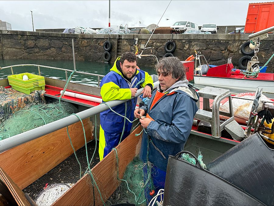 Ramón y Aitor arreglan las redes antes de otra salida al mar, en el puerto de Porto do Son