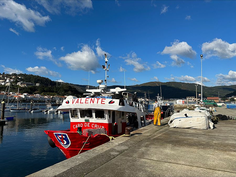 Juan, junto a su barco en el puerto de Muros