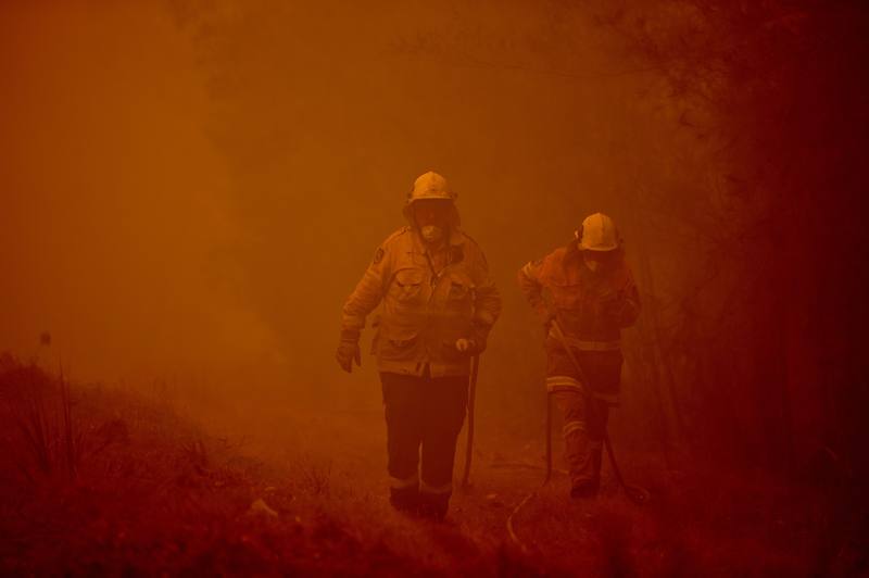 Dos bomberos trabajan en la extinción de un fuego en Moruya