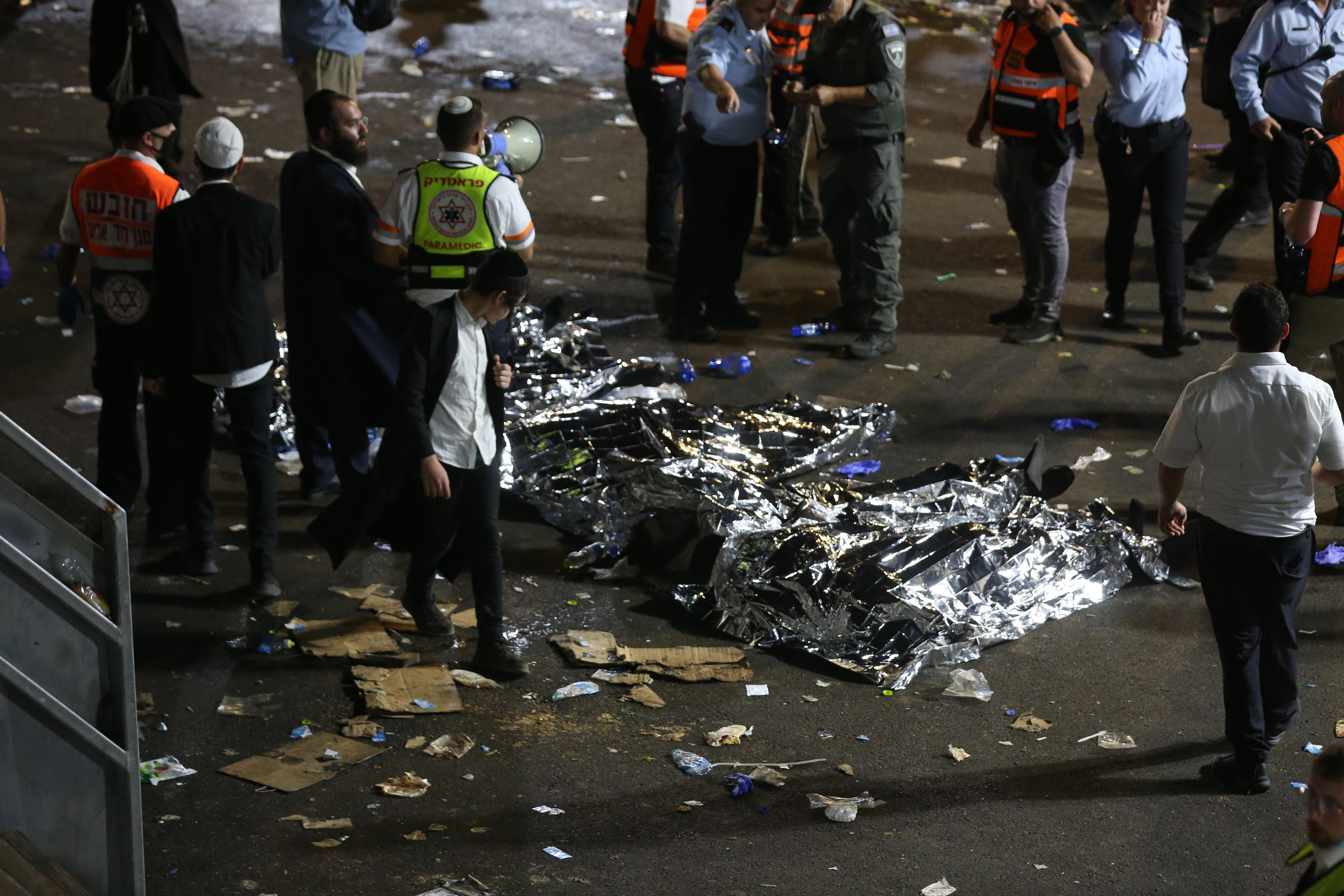 Los cuerpos de varias víctimas de la estampida yacen en el suelo. Decenas de miles de personas celebraban la festividad religiosa de Lag BaOmer en el monte Meron, norte de Israel. Era la primera celebración masiva autorizada desde el comienzo de la p