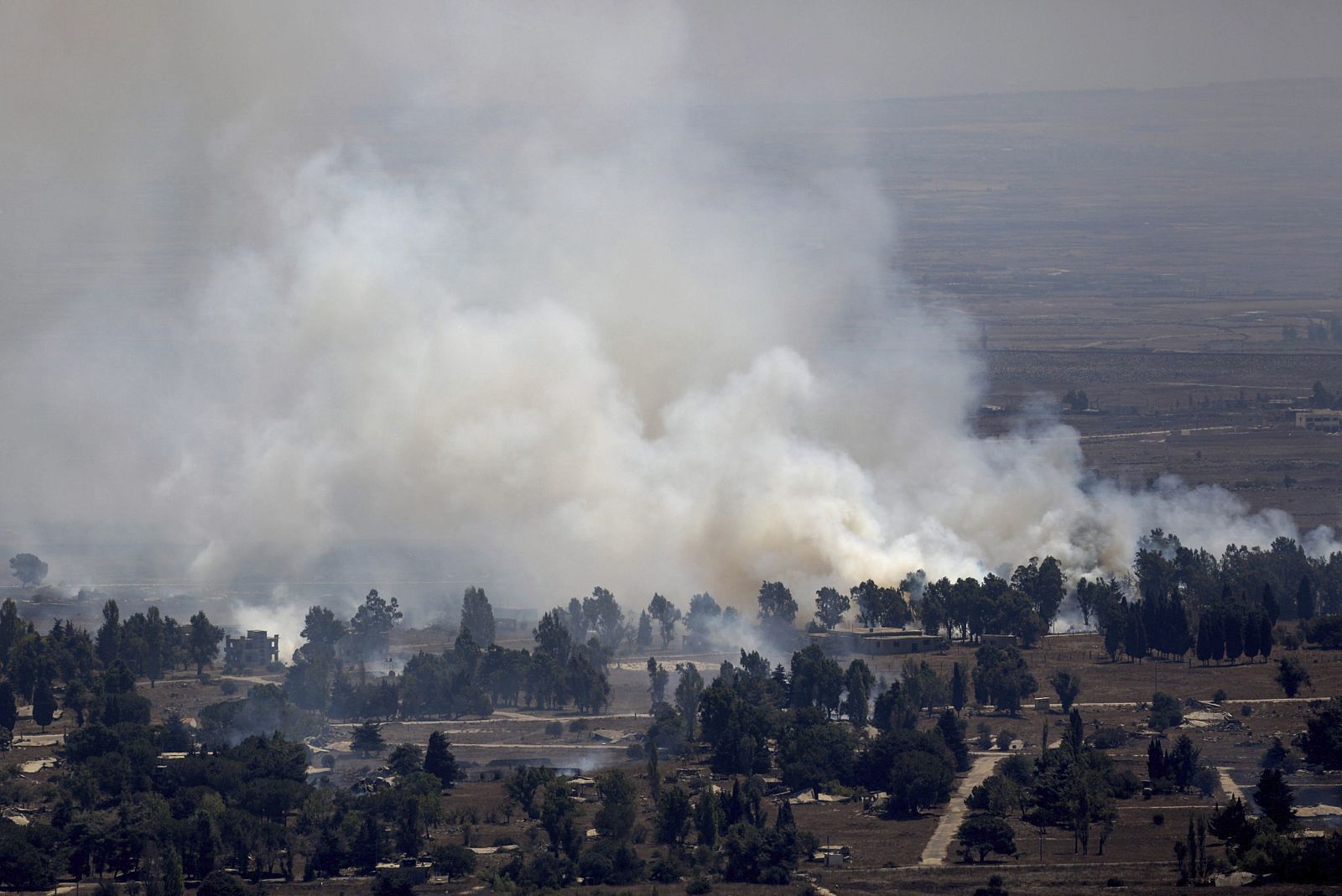 Una columna de humo se eleva en la frontera entre Siria e Israel después de los combates entre el ejército sirio y los rebeldes.