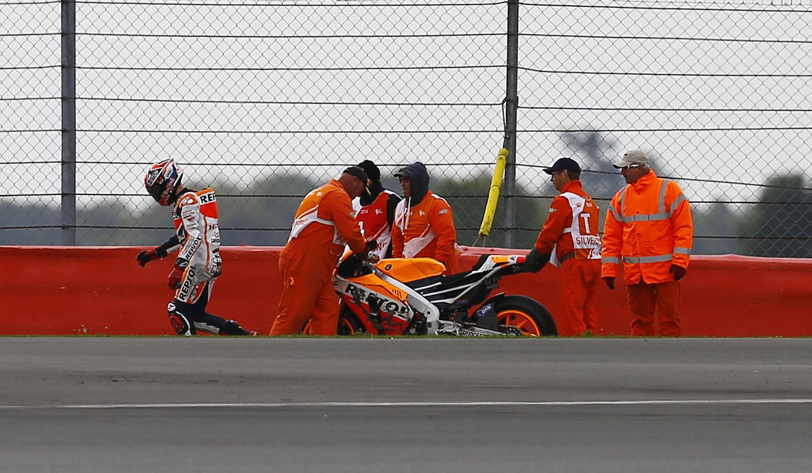 Honda MotoGP rider Marc Marquez of Spain walks away after a fall during the third practice session for the British Grand Prix at the Silverstone Race Circuit
