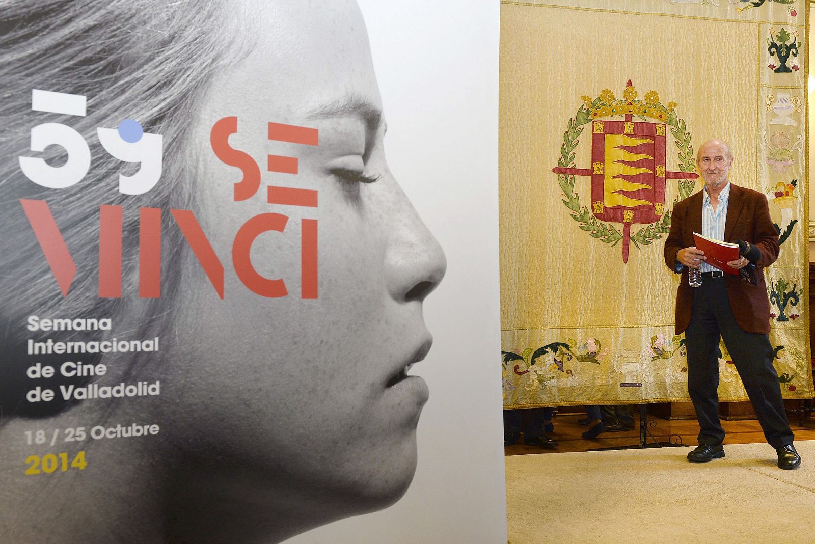 El director del Festival Internacional de Cine de Valladolid, Javier Angulo, junto a un cartel del certamen, durante la presentación hoy de su 59 edición que abrirán el próximo 18 de octubre.