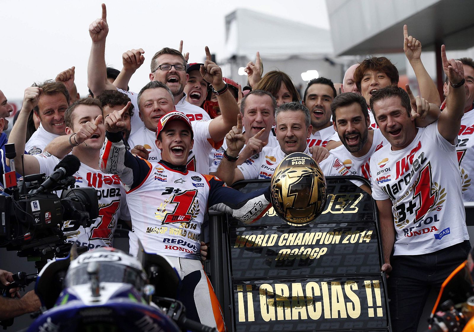 Honda MotoGP rider Marc Marquez of Spain poses for photos with his team members after he finished in second place at the Japanese Grand Prix at the Twin Ring Motegi circuit in Motegi