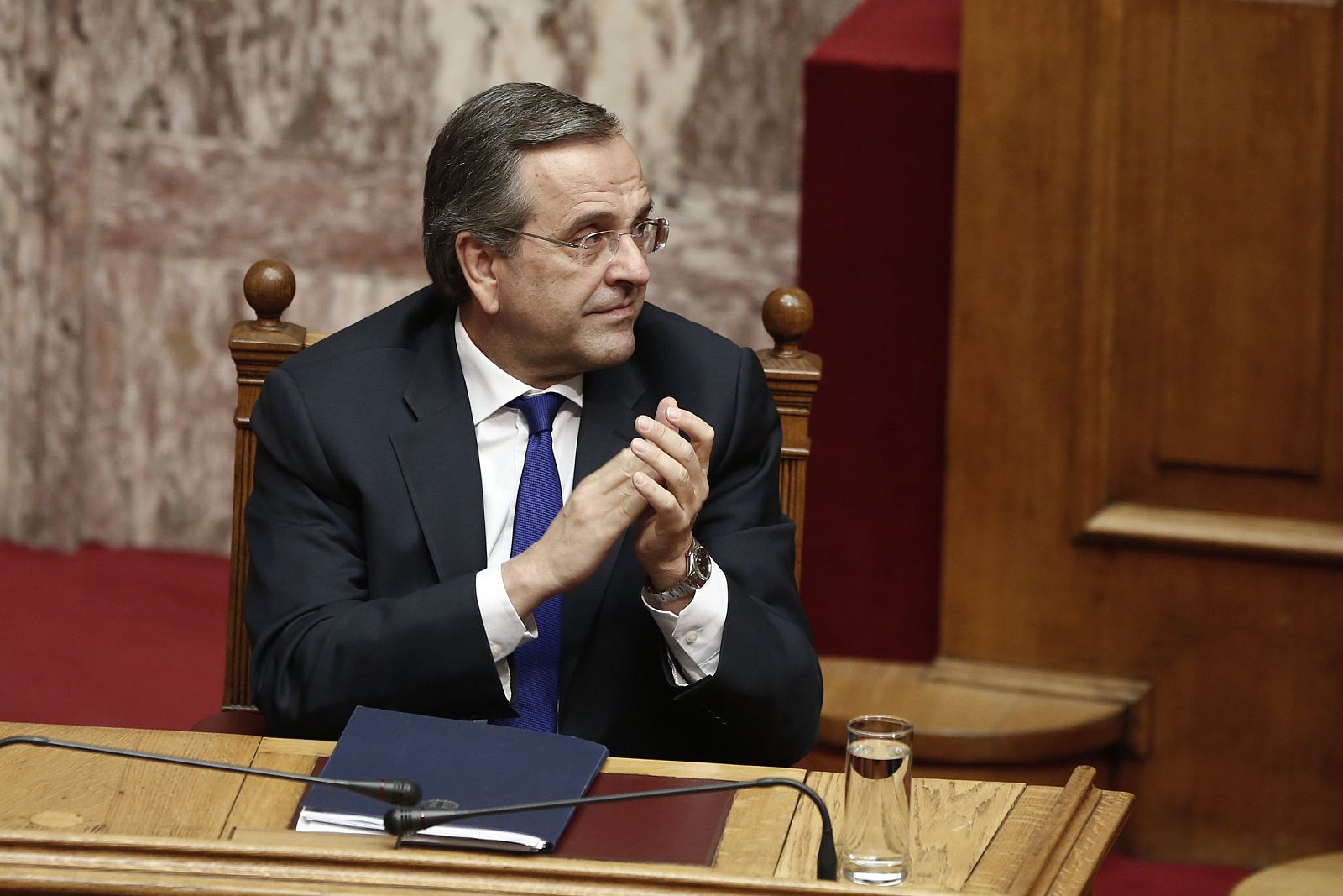 Greece's Prime Minister Samaras applauds a lawmaker before a confidence vote for the country's coalition government in Athens