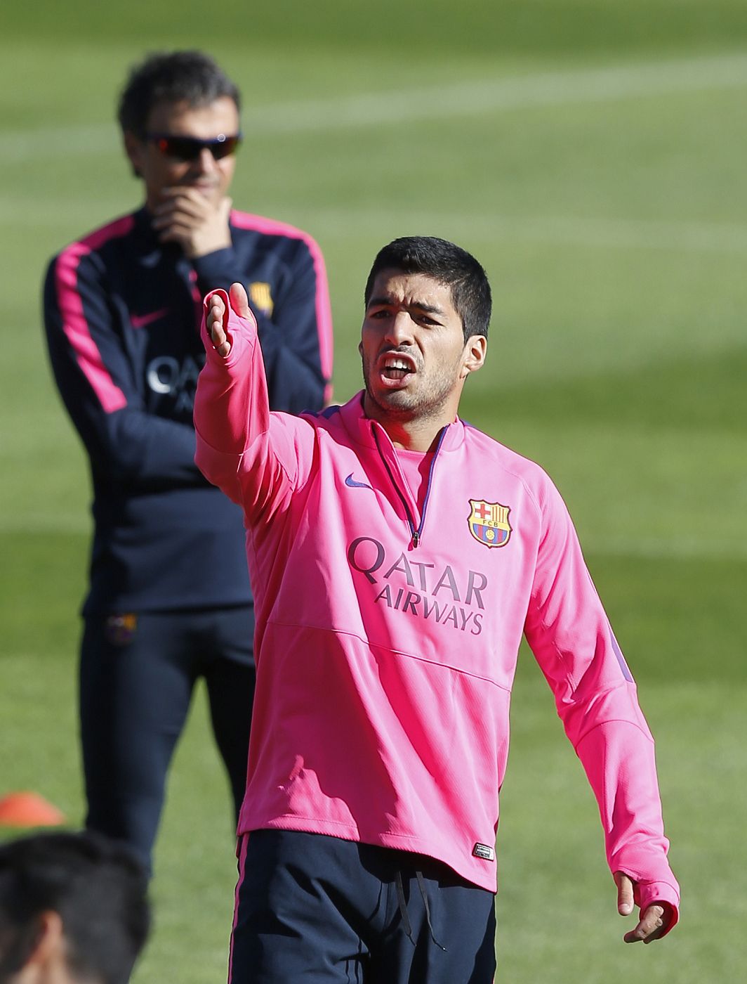 Barcelona's coach Luis Enrique (L) looks on as Luis Suarez gestures to his teammate during a training session at Ciutat Esportiva Joan Gamper in Sant Joan Despi