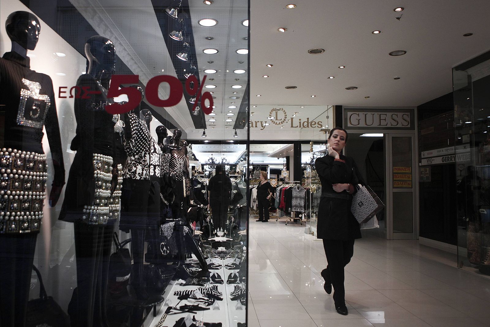 A woman leaves a shop at the commercial Ermou street in central Athens Imagen de un centro comercial situado en Atenas Grecia