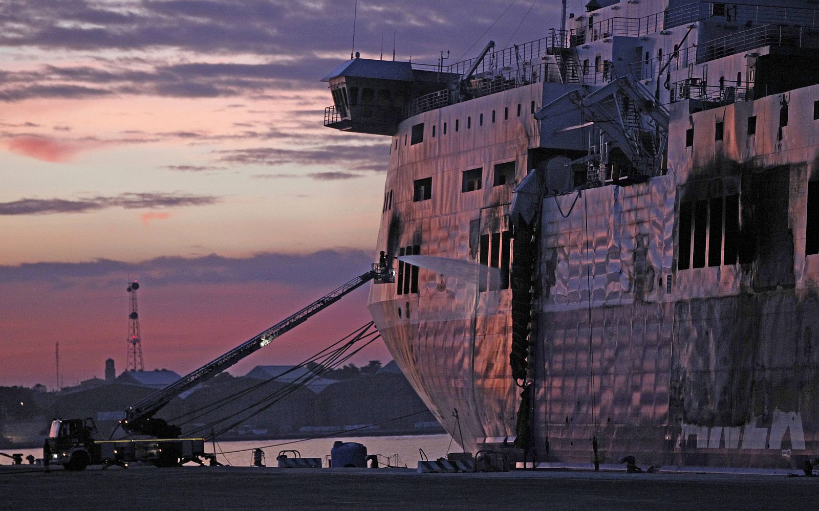 Un bombero apaga los focos aún sin extinguir del ferri 'Norman Atlantic', en el puerto italiano de Bríndisi.