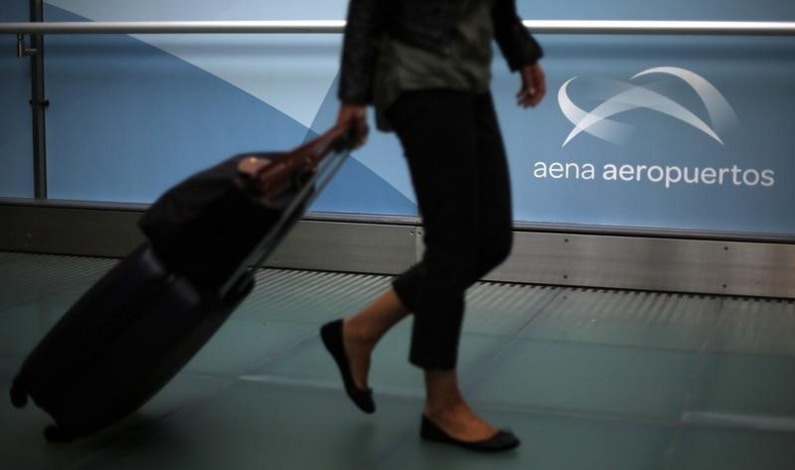 Una pasajera pasa por un pasillo de un aeropuerto español
