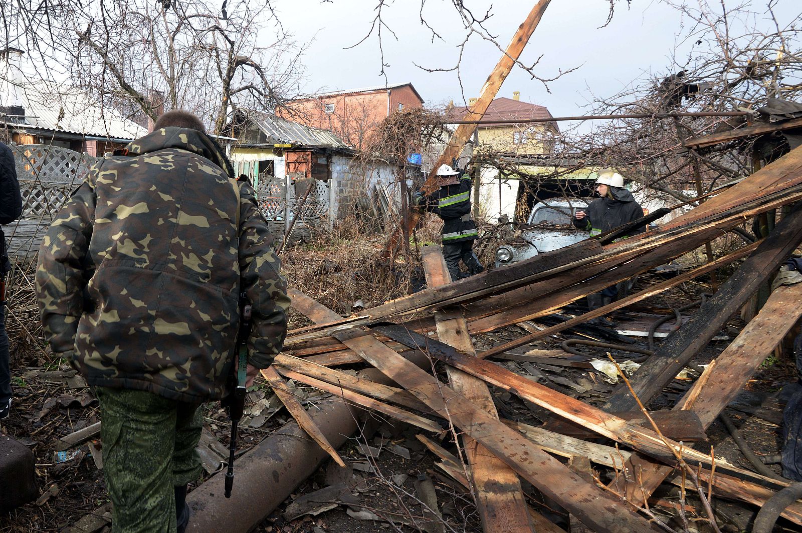 Un soldado prorruso camina cerca de una casa destruida después de los bombardeos