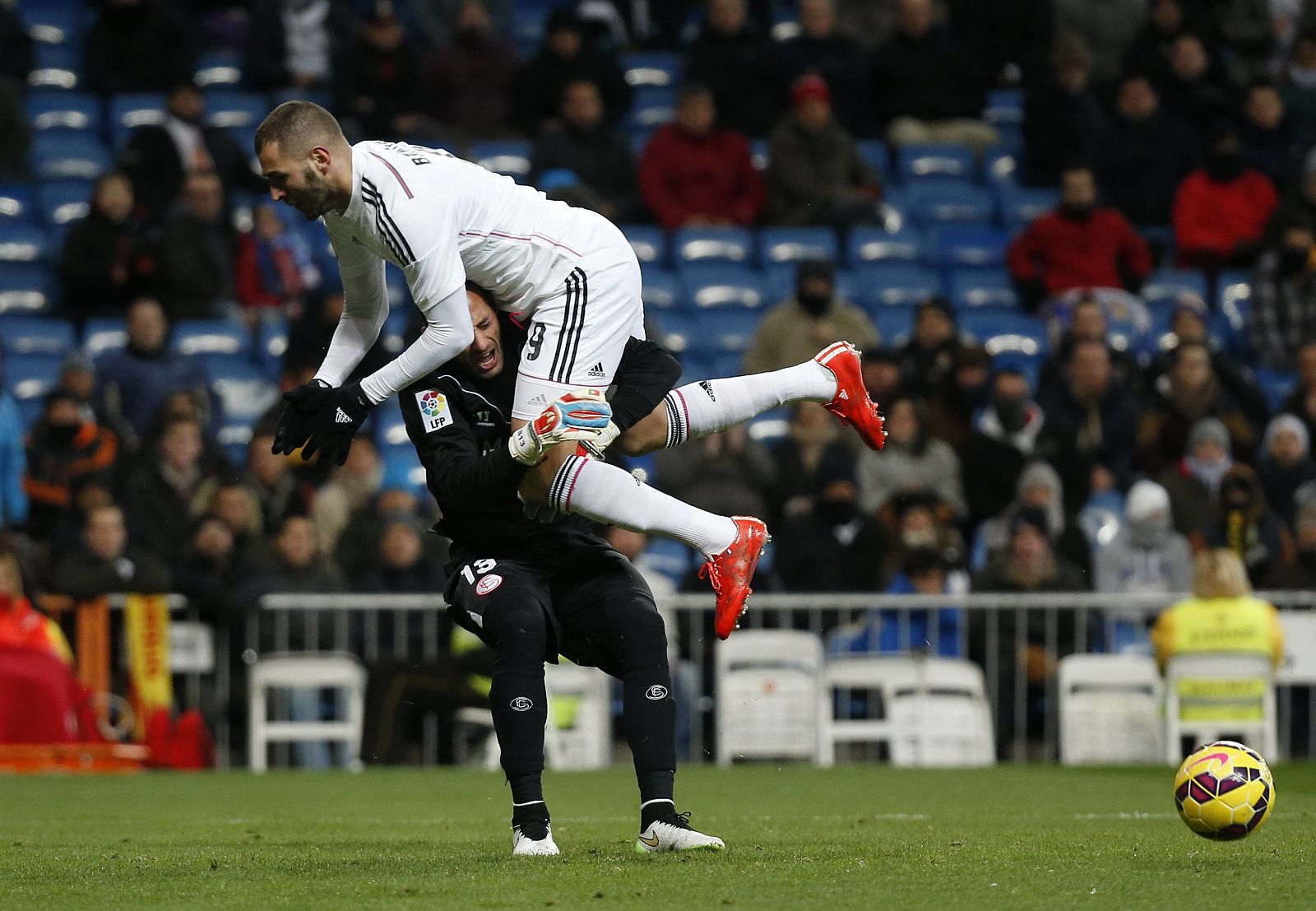 Real Madrid's Benzema clashes with Sevilla's Beto during their Spanish first division soccer match at Santiago Bernabeu stadium in Madrid