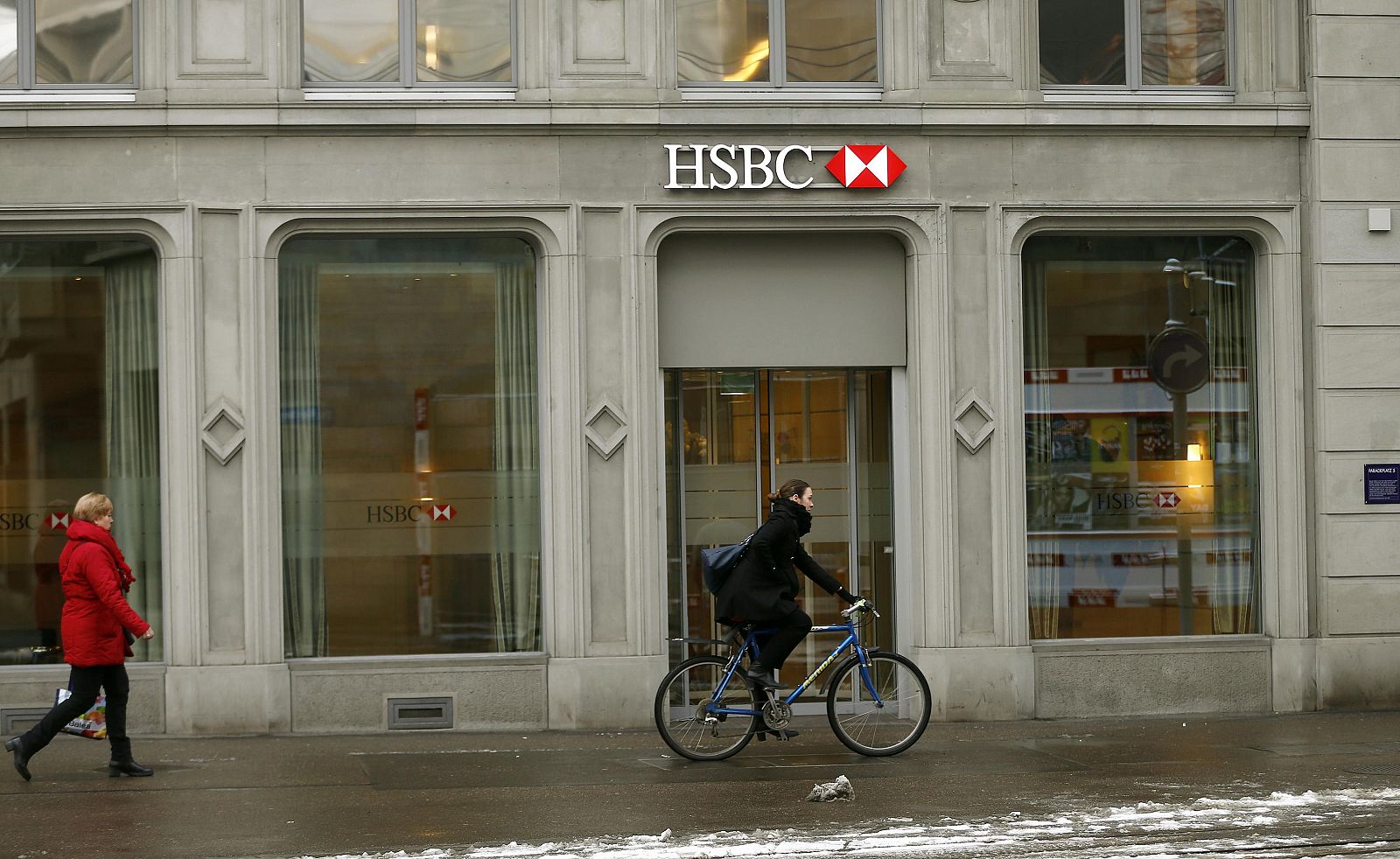 Una ciclista pasa por delante de una sede del HSBC en Zurich