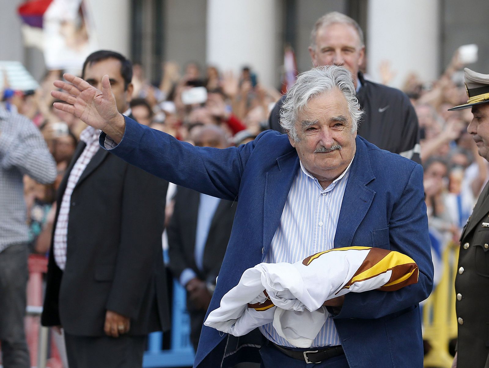 Uruguay's President Jose Mujica waves to the people after receiving the Uruguayan flag on the last working day of his term in Montevideo