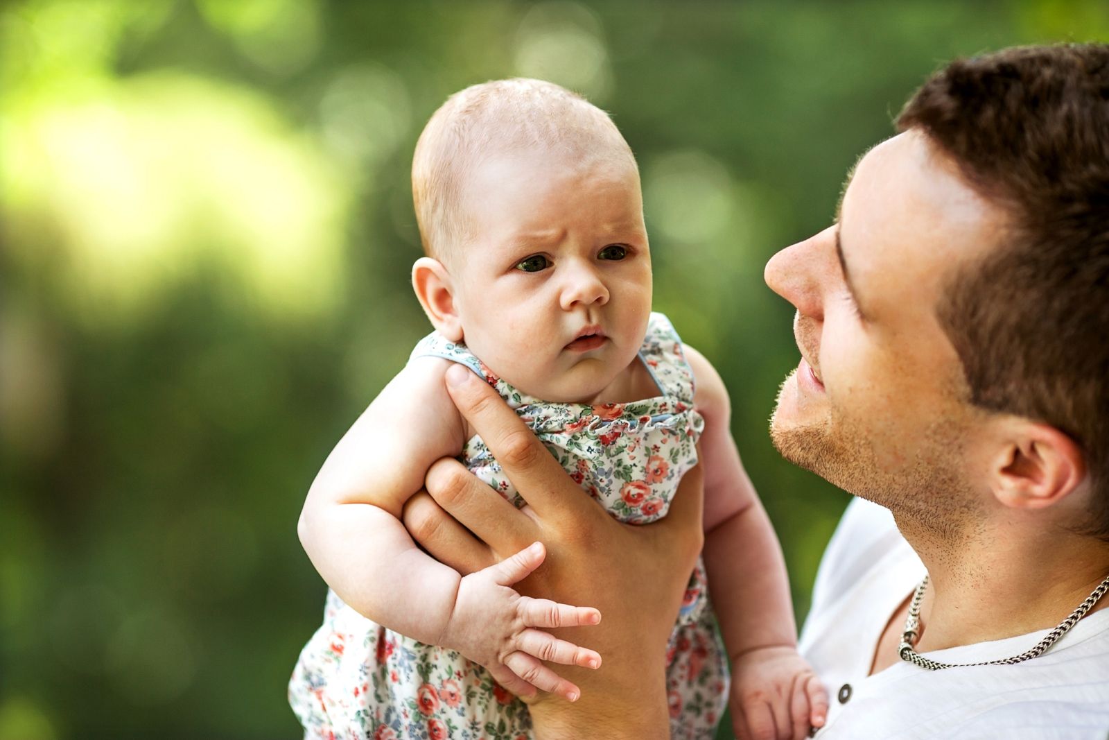Un padre hablando con su hija en el parque.