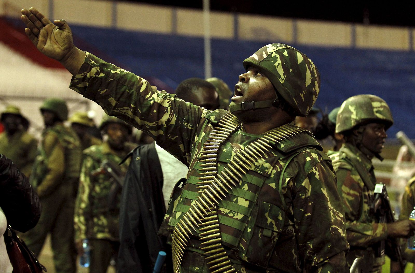 A policeman controls issued orders to his juniors when people rescued from the Garissa University attack meet their relatives at Nyayo stadium in Nairobi