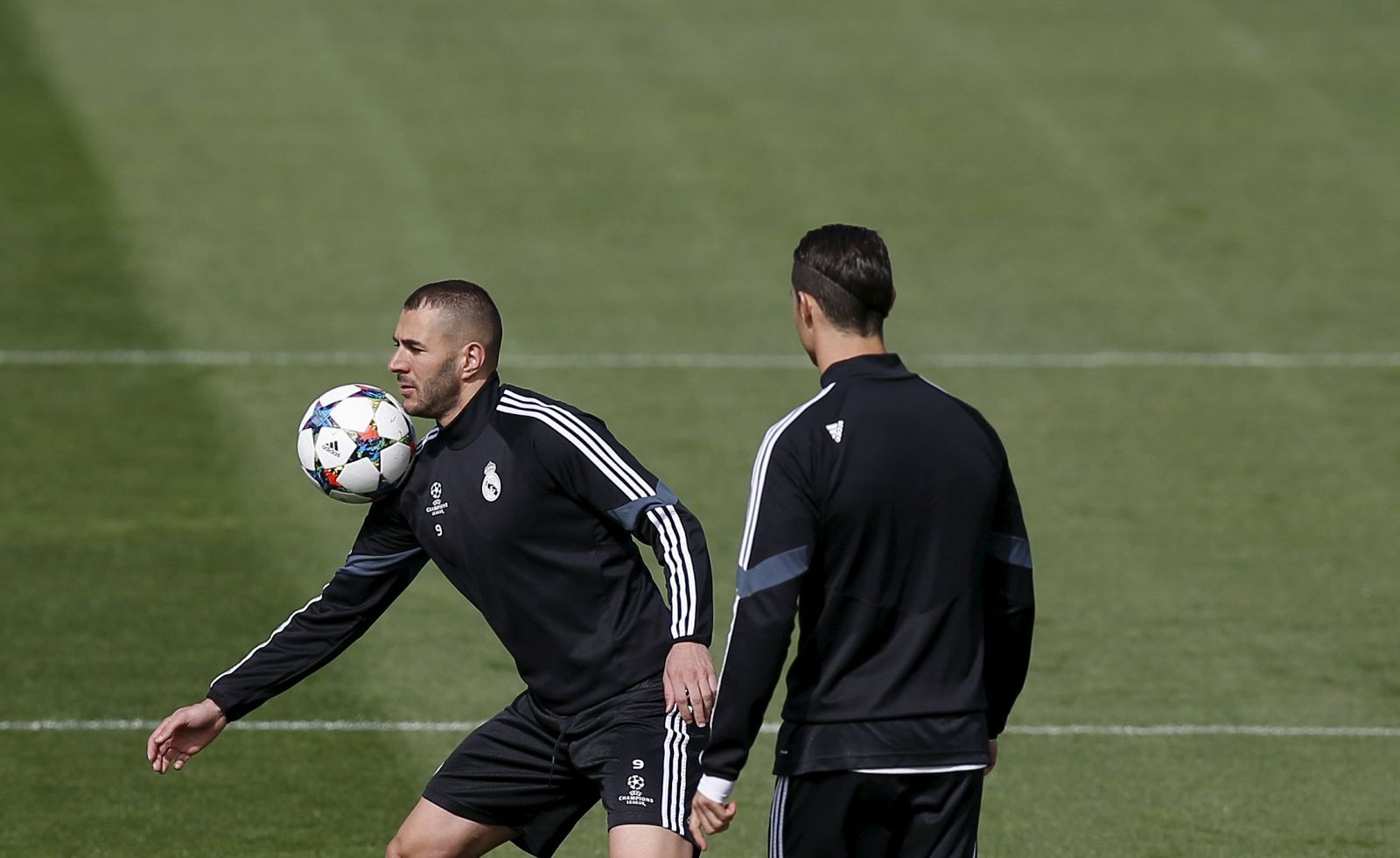 Real Madrid's Cristiano Ronaldo looks on as teammate Benzema controls the ball during their training session at Valdebebas sports grounds in Madrid