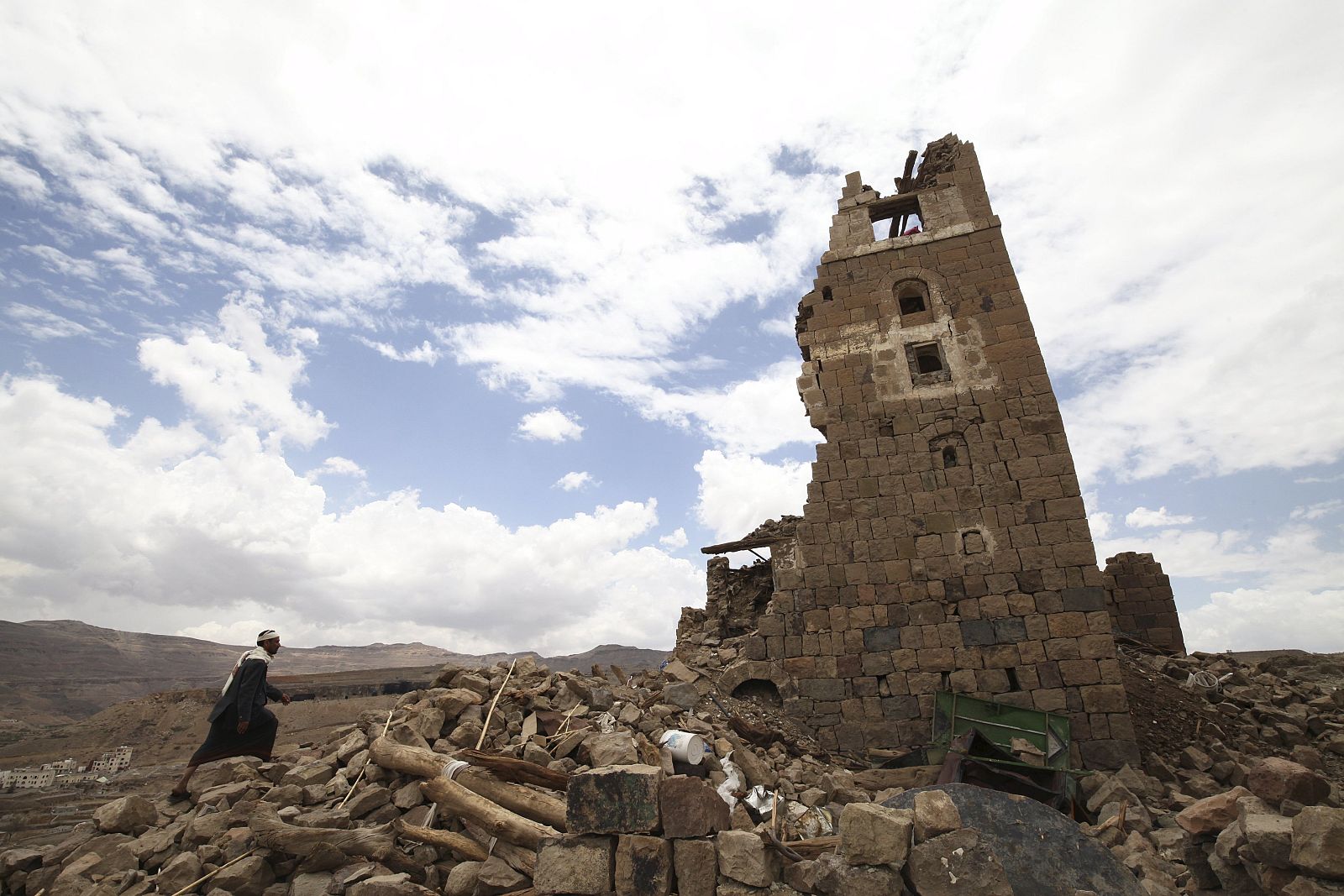Man walks to a house that was damaged during an airstrike carried out by the Saudi-led coalition in Faj Attan village, Sanaa, Yemen