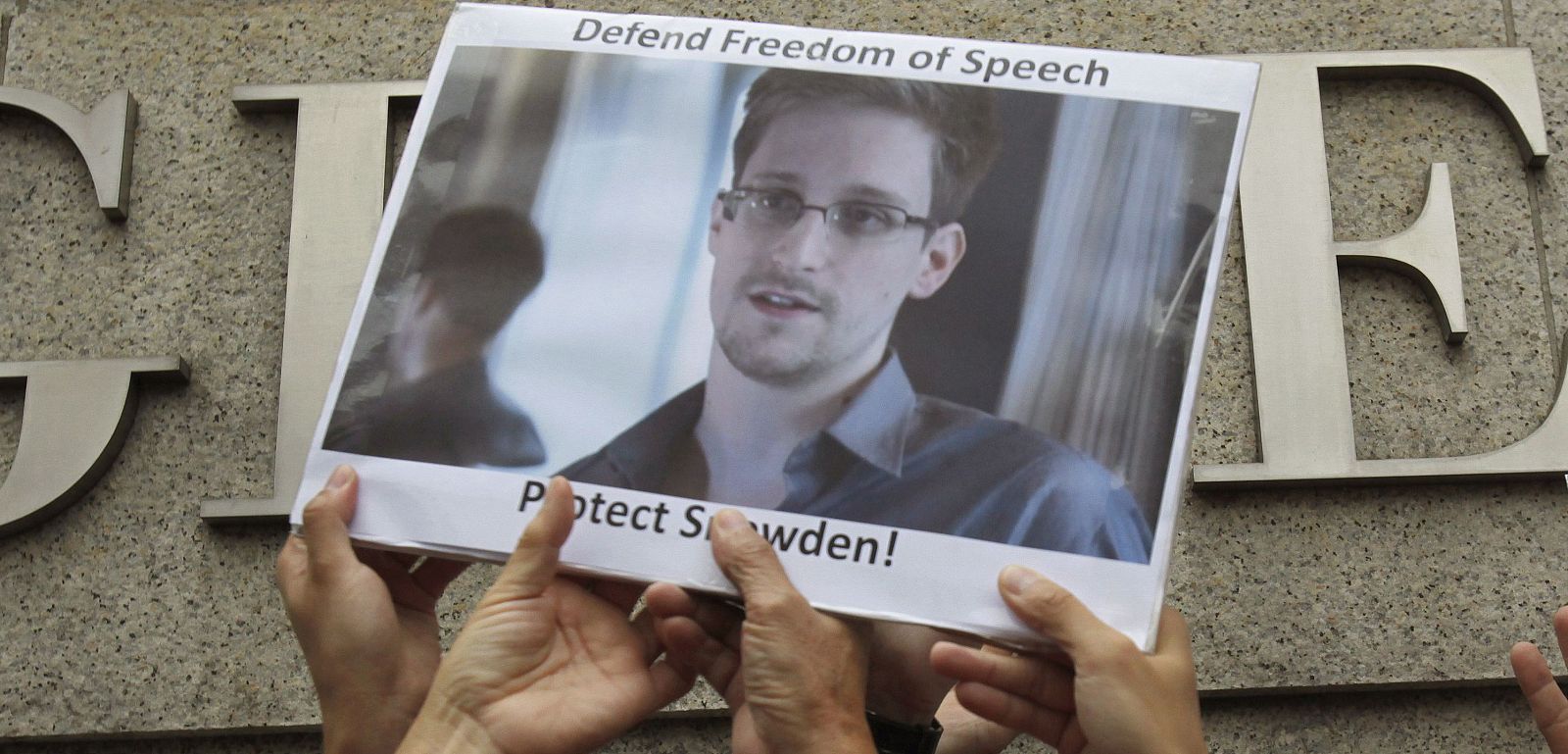 File photo of protesters supporting Snowden hold a photo of him during a demonstration outside the U.S. Consulate in Hong Kong