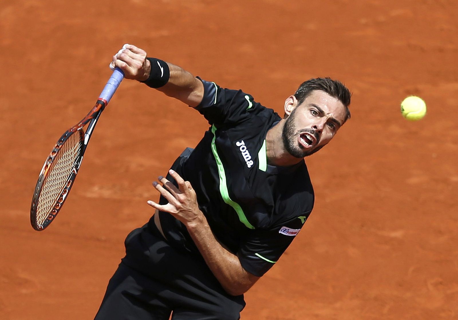 Marcel Granollers of Spain plays a shot to Roger Federer of Switzerland during their men's singles match at the French Open tennis tournament at the Roland Garros stadium in Paris