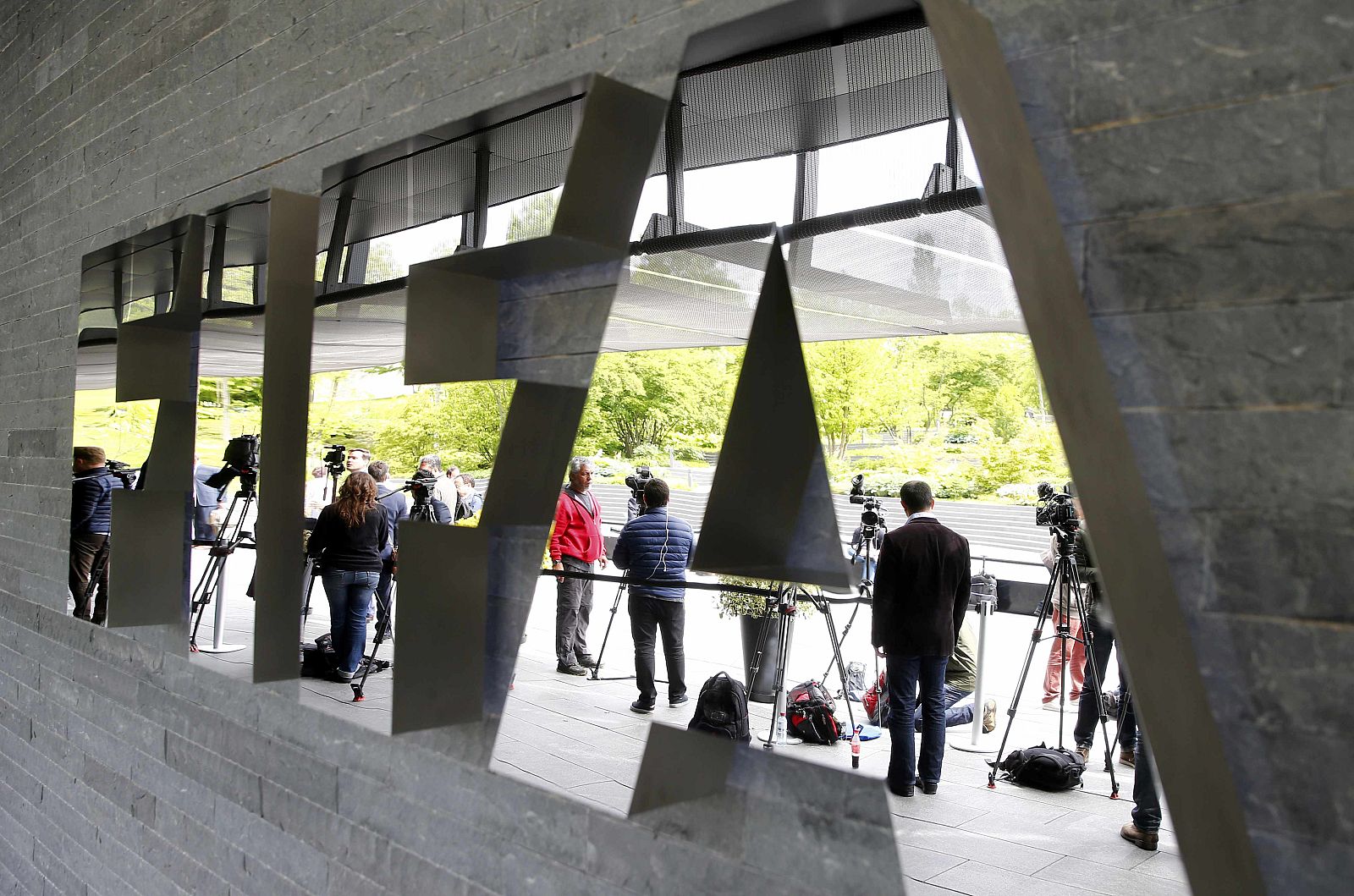 Members of the media stand in front of the FIFA headquarters in Zurich