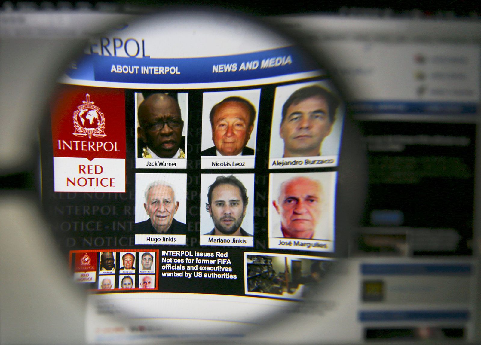 The homepage of the Interpol website is seen through a magnifying glass in this picture illustration taken in Berlin