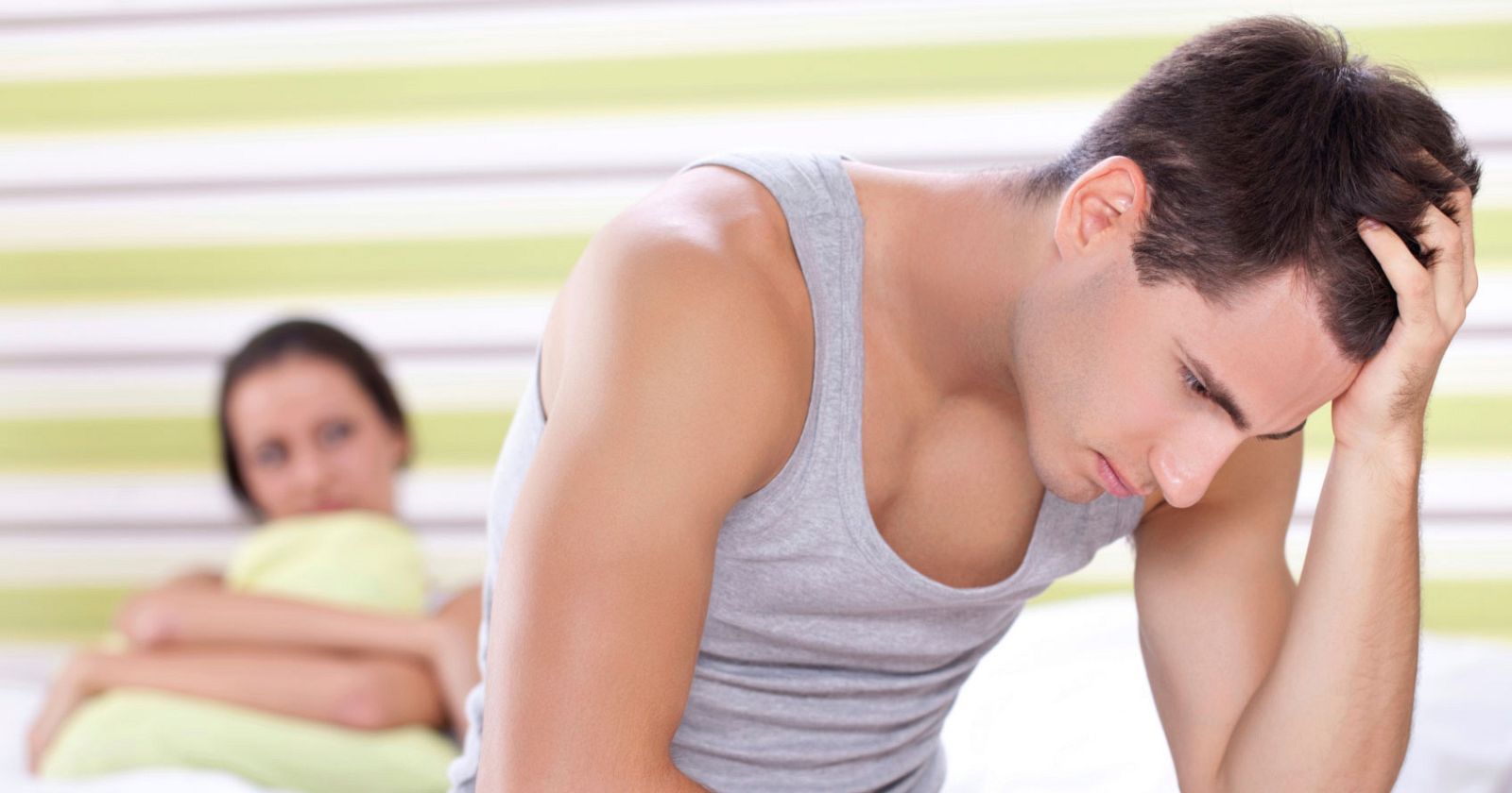 Un hombre preocupado sentado sobre la cama.