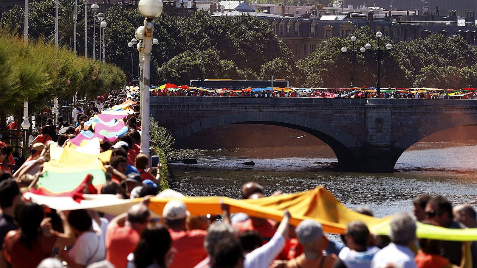 Una cadena humana de telas une los seis puentes sobre el río Urumea en San Sebastián