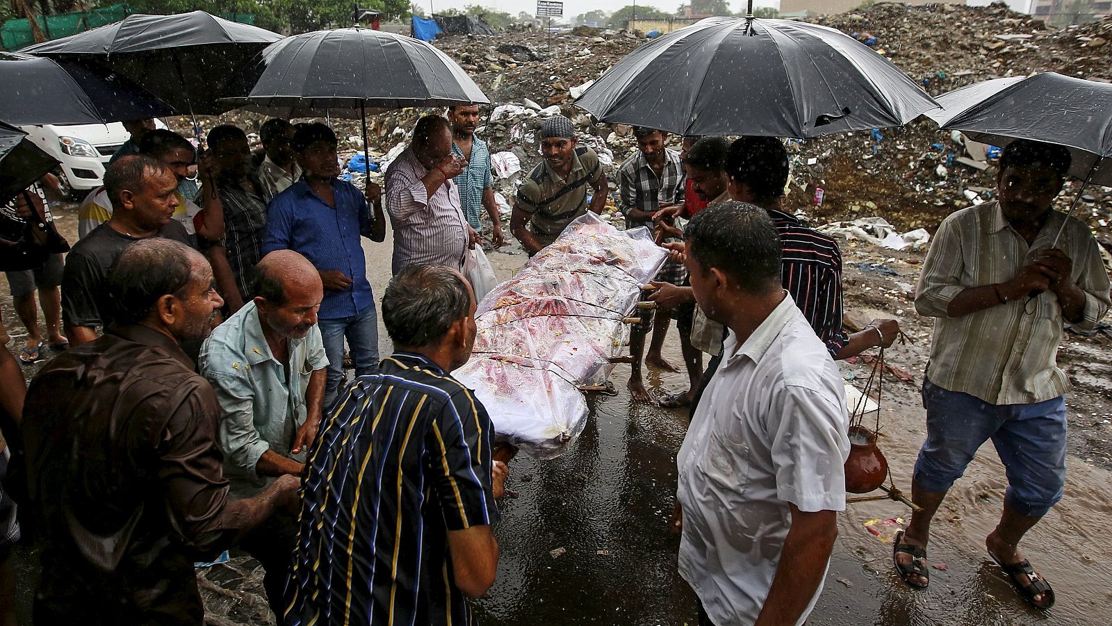 Varias personas entierran a uno de los fallecidos por el consumo de alcohol adulterado en Bombay, India.