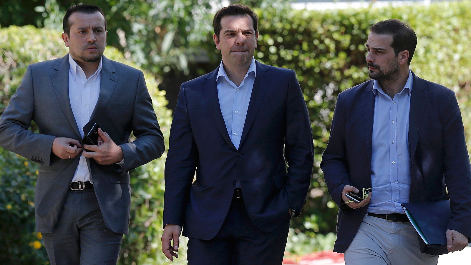 El primer ministro griego Alexis Tsipras, junto al ministro de Estado Nikos Papas y el protavoz del Gobierno, Gabriel Sakelaridis abandonando el Palacio Presidencial. REUTERS/Christian Hartmann