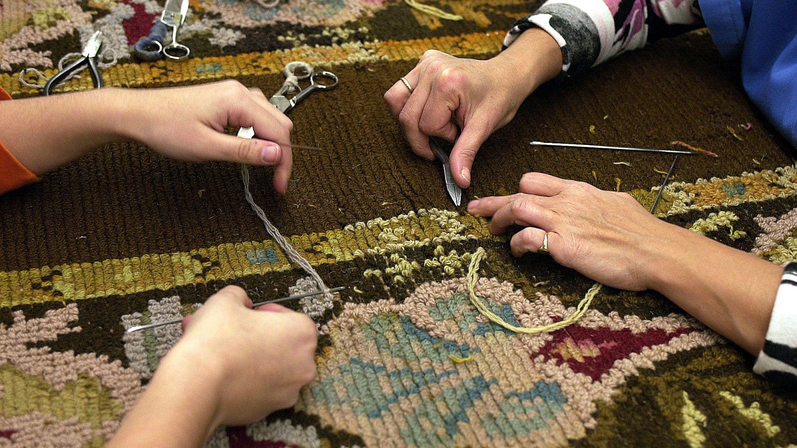 Personas trabajando sobre un tapiz