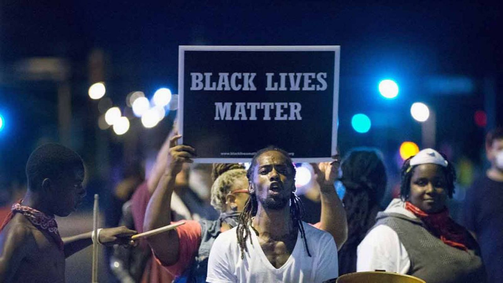 Manifestantes en Ferguson portan un cartel contra el racismo.