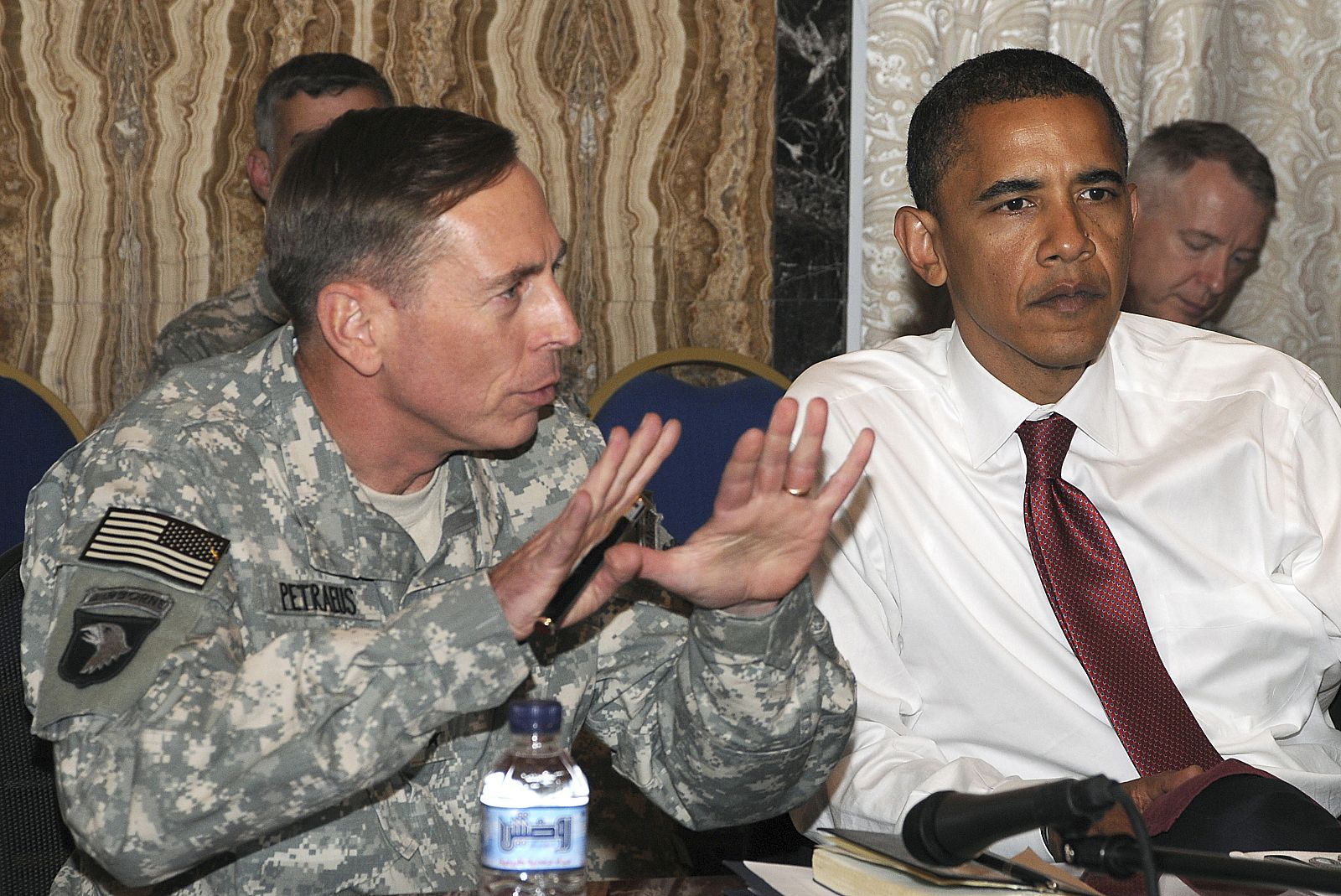 Barack Obama escucha al general Petraeus en Bagdad