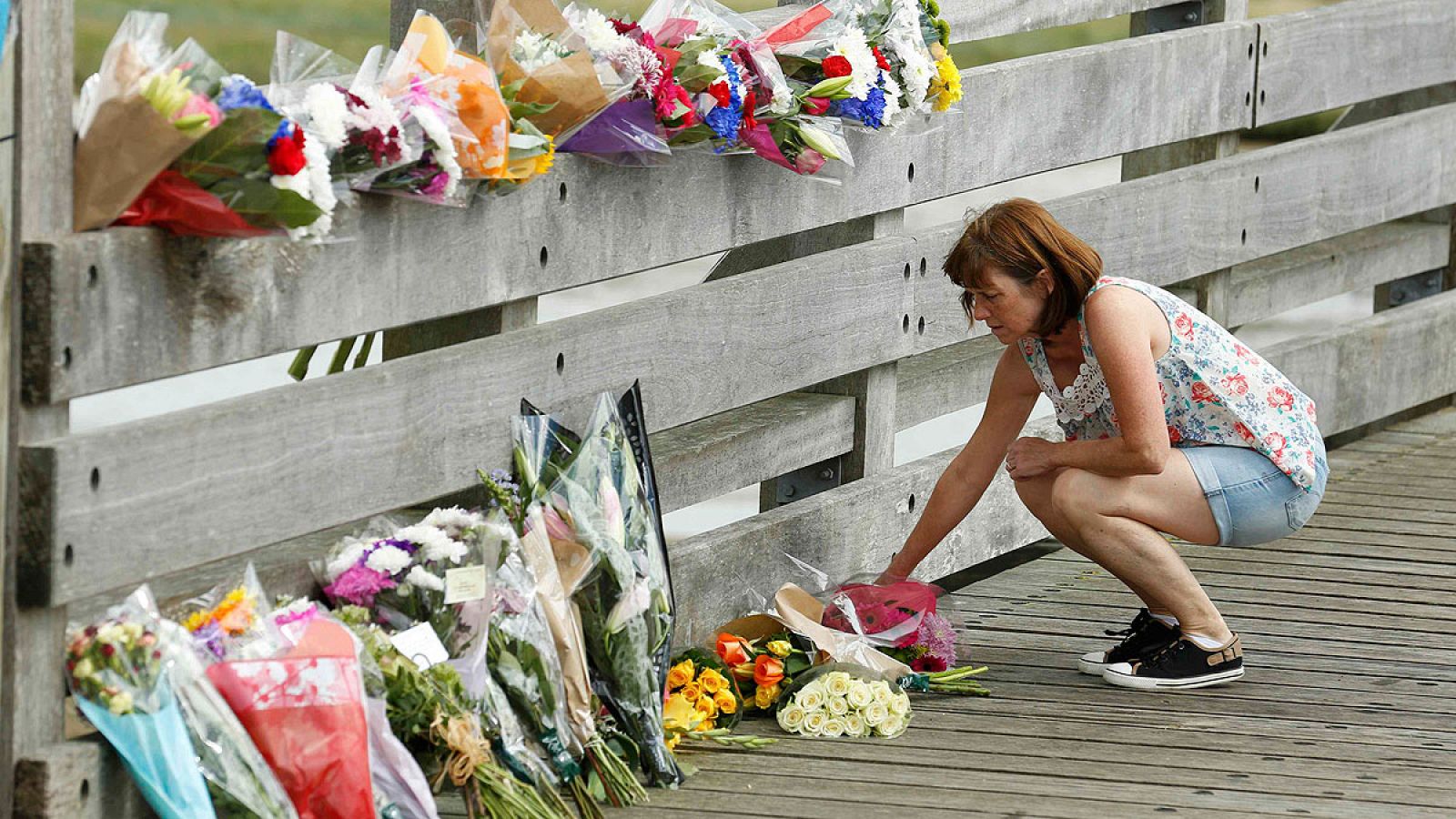 Una mujer deposita flores en Shoreham cerca del lugar del accidente