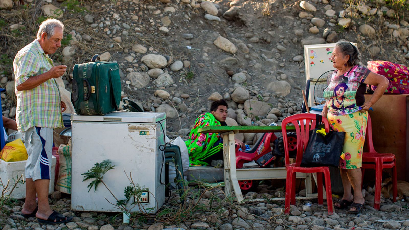 Una familia colombiana descansa con sus pertenencias tras cruzar el río Tachira desde Venezuela.