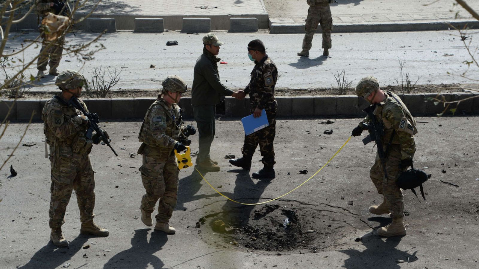 Soldados de la OTAN inspeccionan la zona donde ha explosionado el coche bomba
