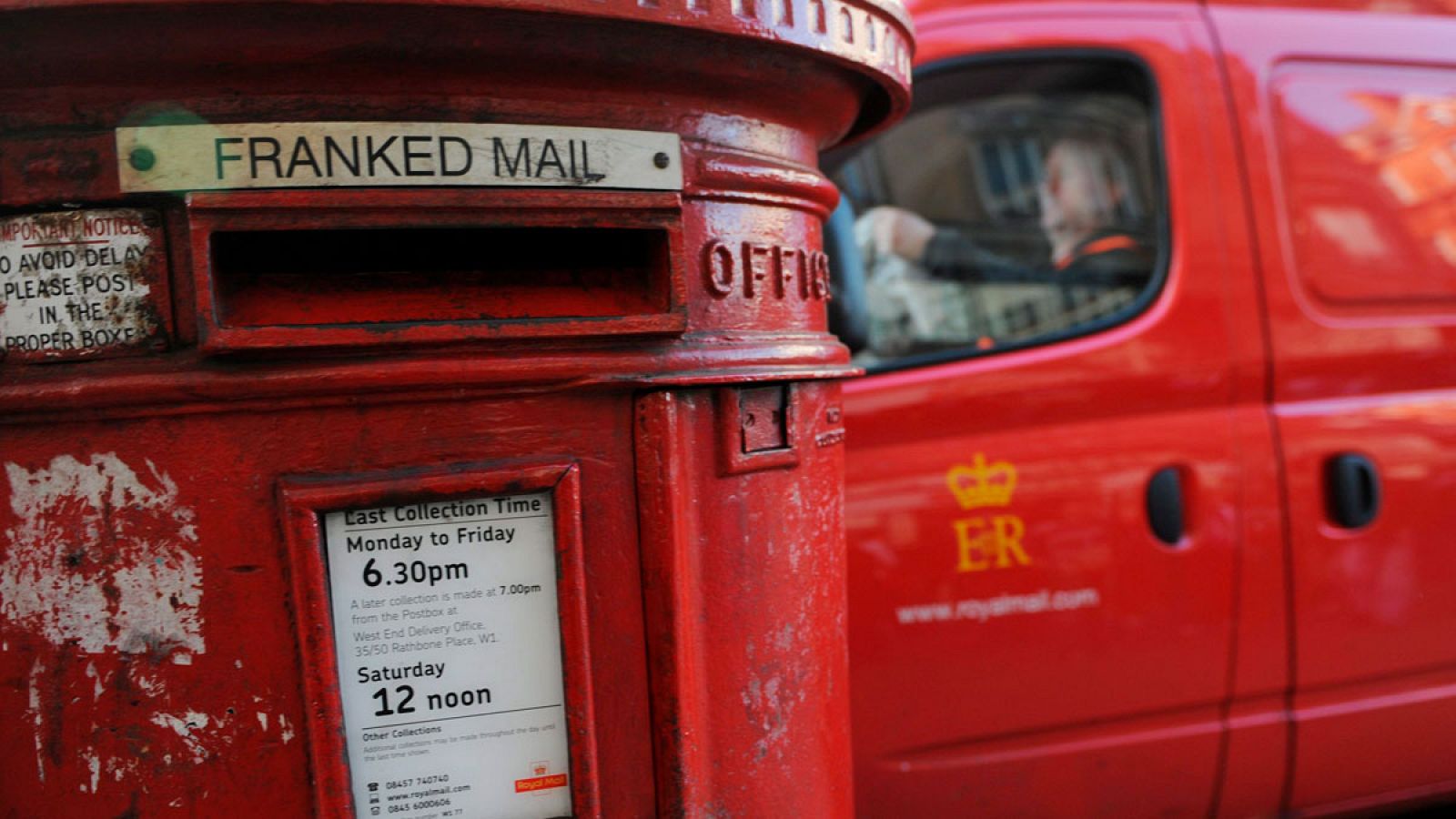 Un trabajador del Royal Mail aparca delante de un buzón en Londres