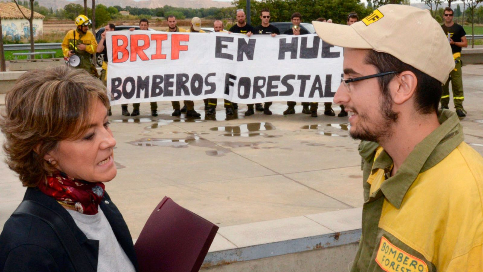 La ministra de Agricultura, Alimentación y Medio Ambiente, Isabel García Tejerina, conversa con uno de los trabajadores de las BRIF en Huesca