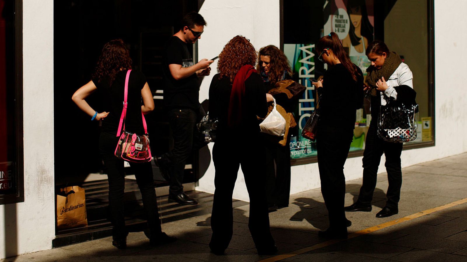 Empleados en el exterior de la tienda en la que trabajan