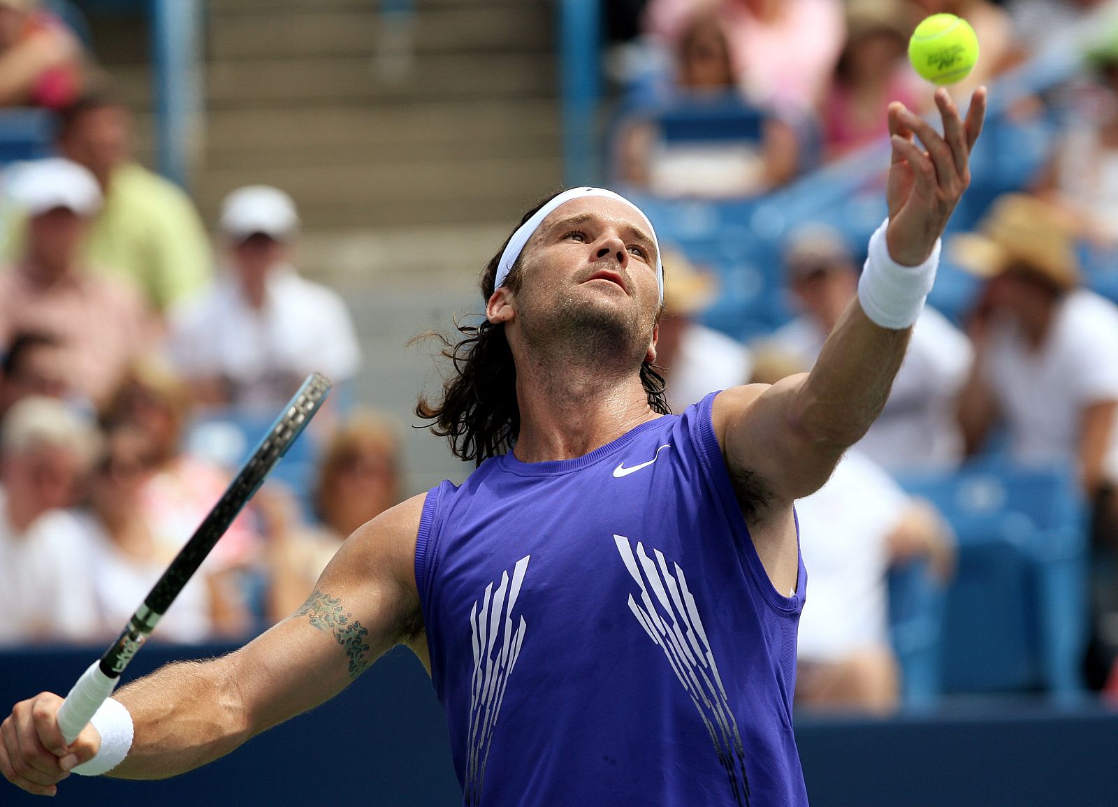 El tenista español Carlos Moyá sirve ante el británico Andy Murray durante el partido por los cuartos de final del torneo de Cincinnati