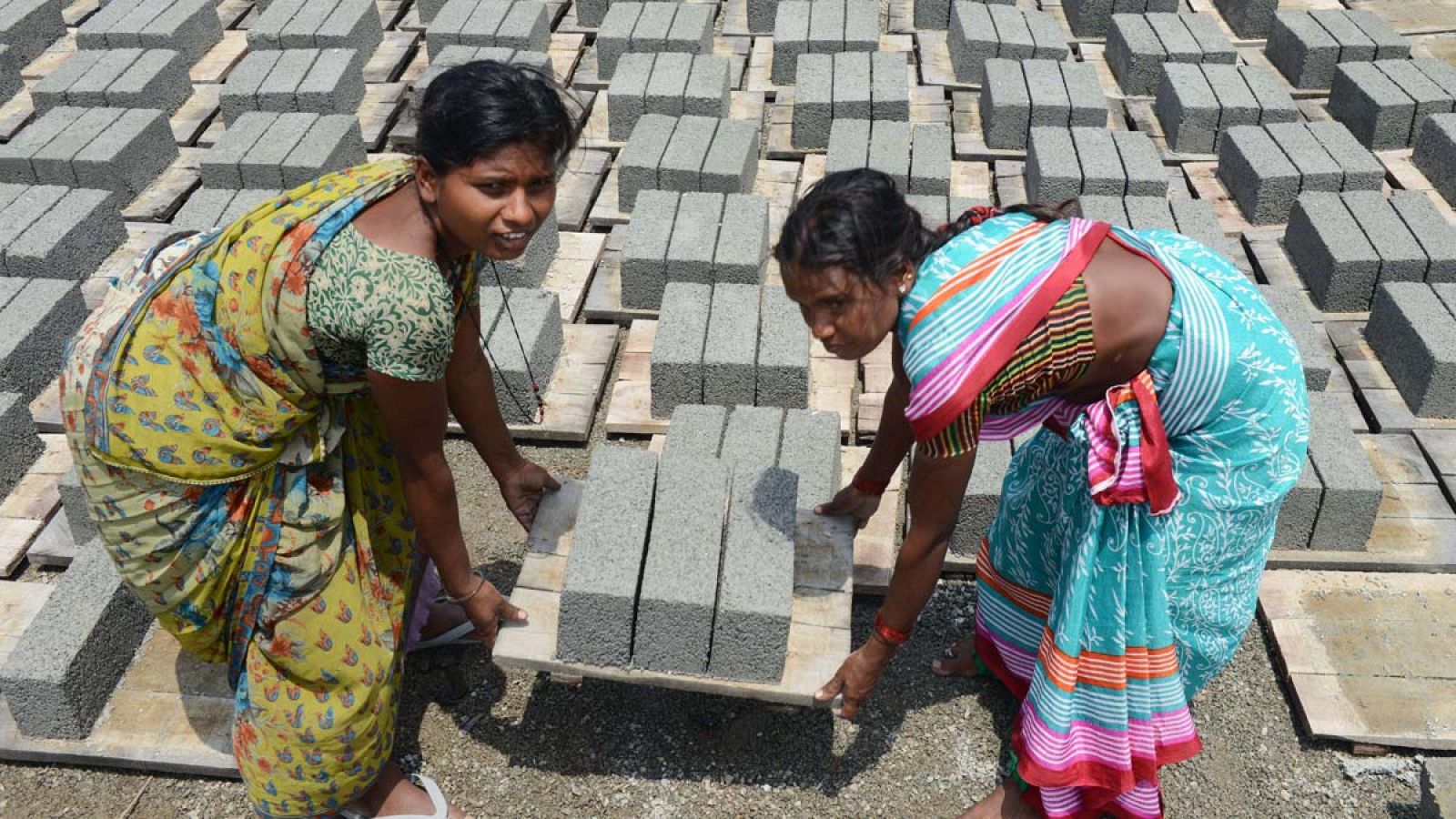 Dos mujeres trabajando en una fábrica de ladrillos de India