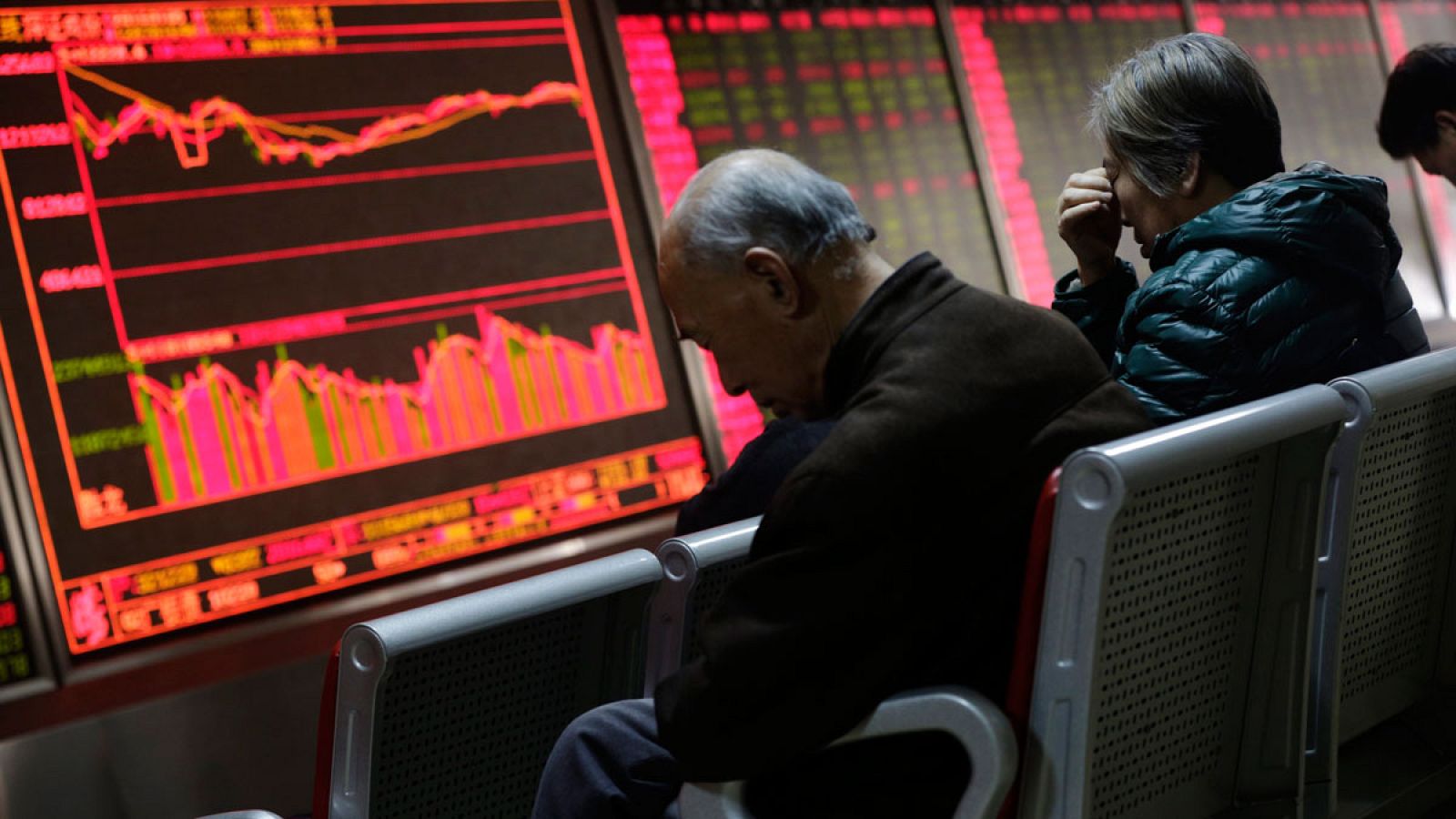 Inversores observan la información bursátil en Pekín (China).