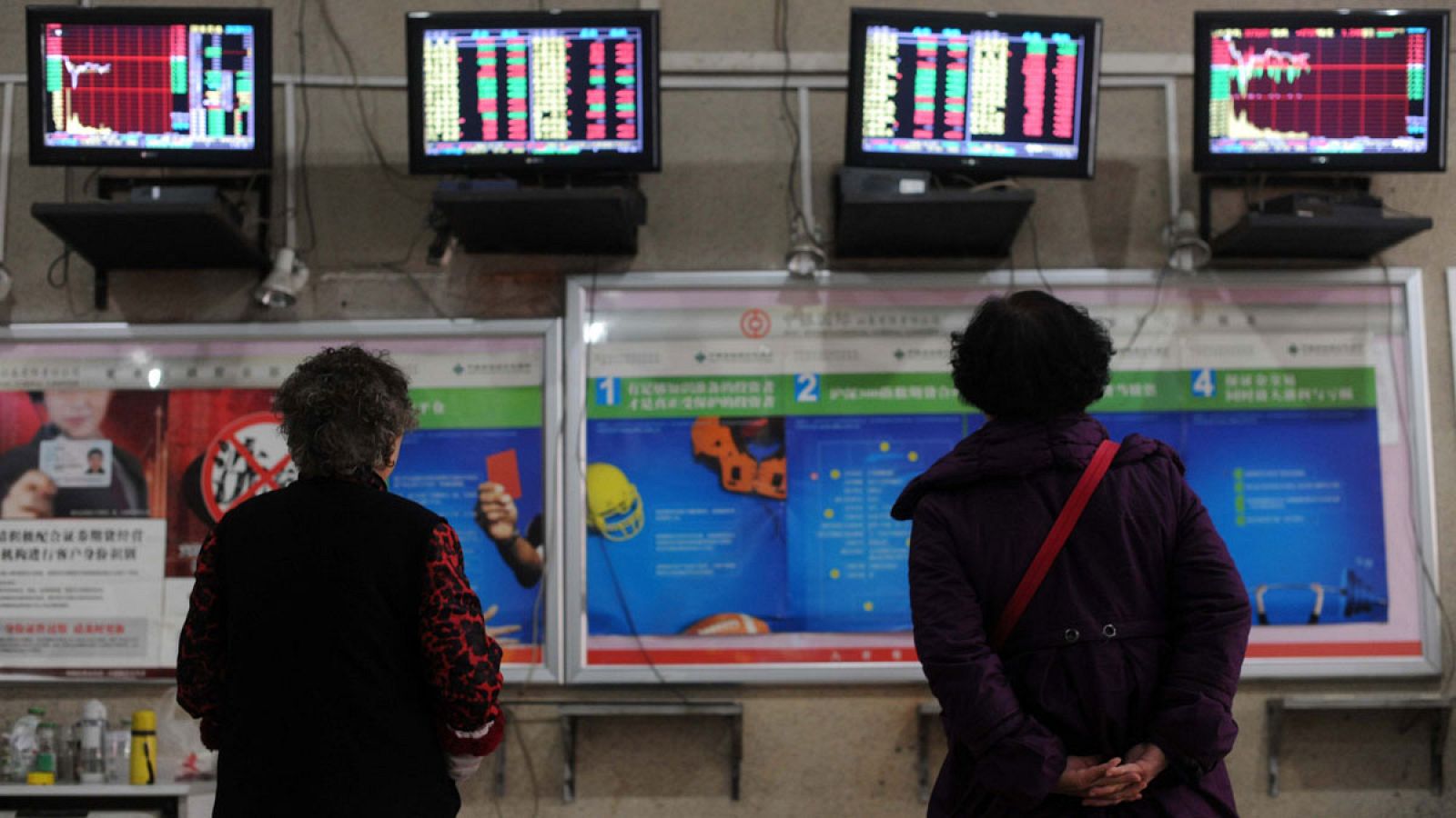 Dos inversoras observan los paneles de cotización en una firma china