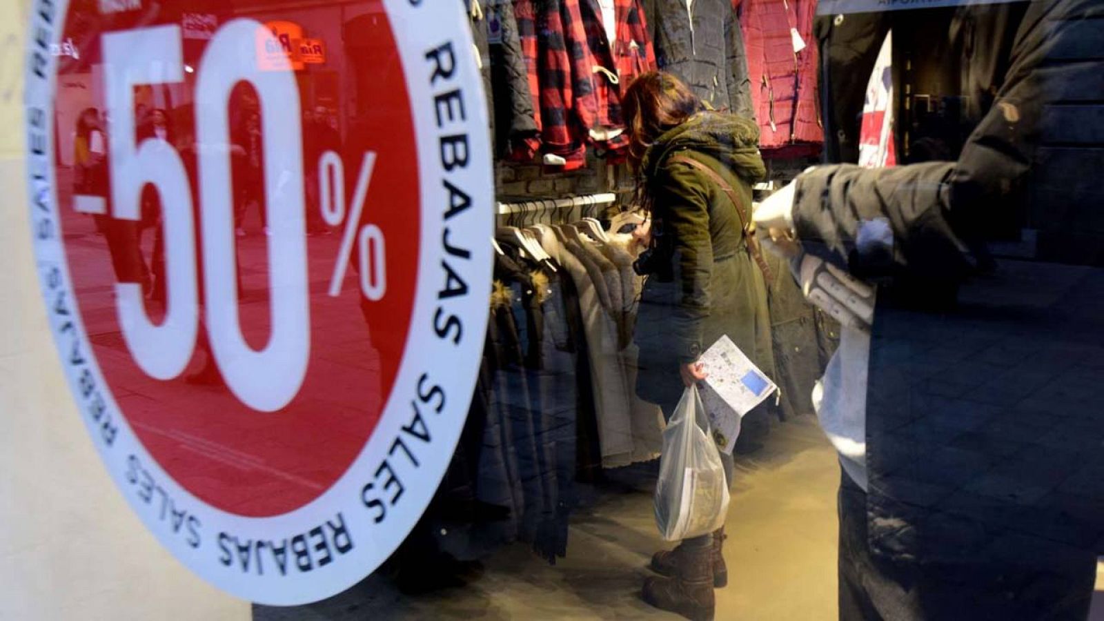 Una mujer mira ropa dentro de una tienda con rebajas en el centro de Madrid