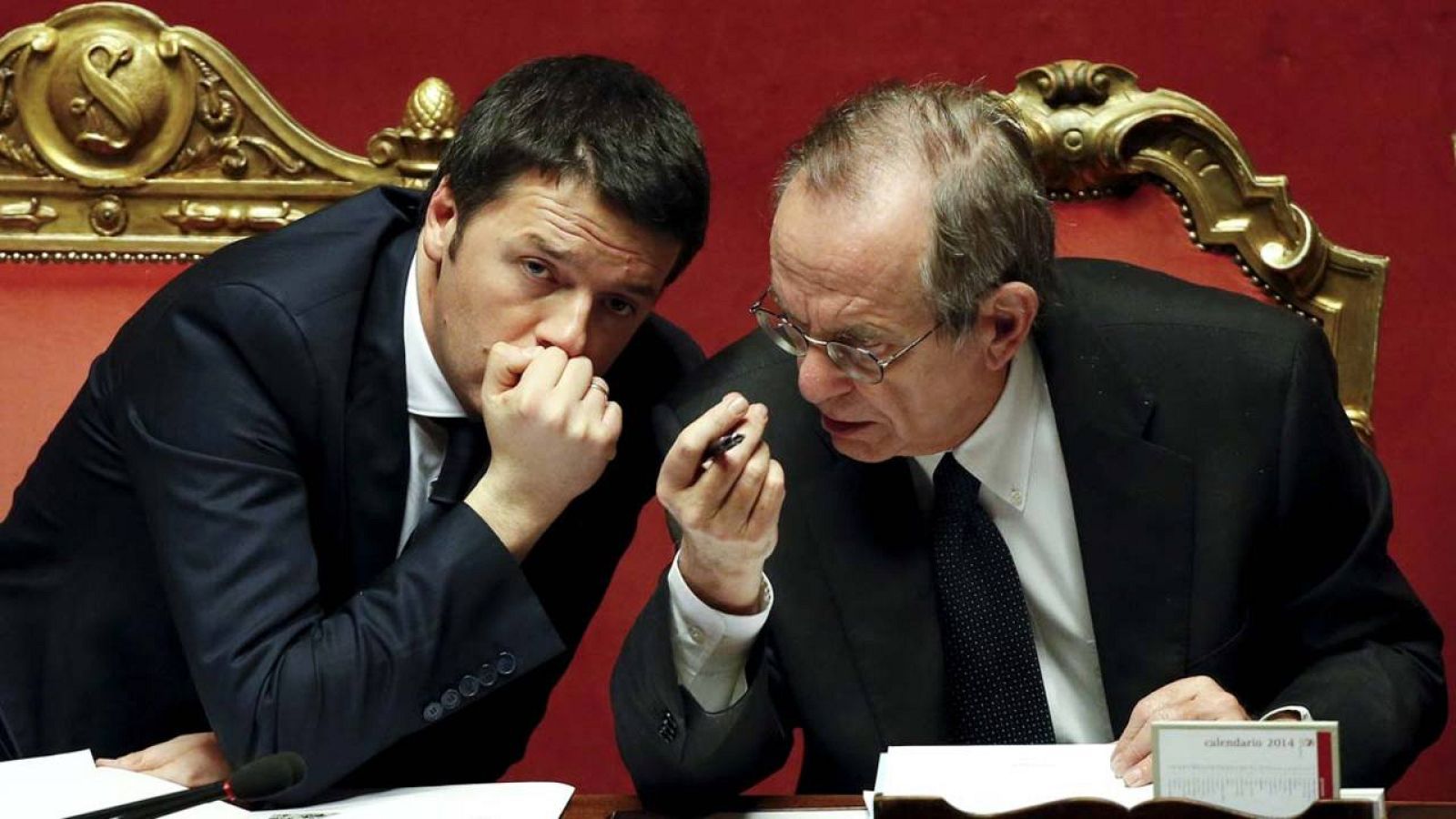 El primer ministro italiano, Matteo Renzi, habla con su ministro de Finanzas, Pier Carlo Padoan, durante un pleno del Senado