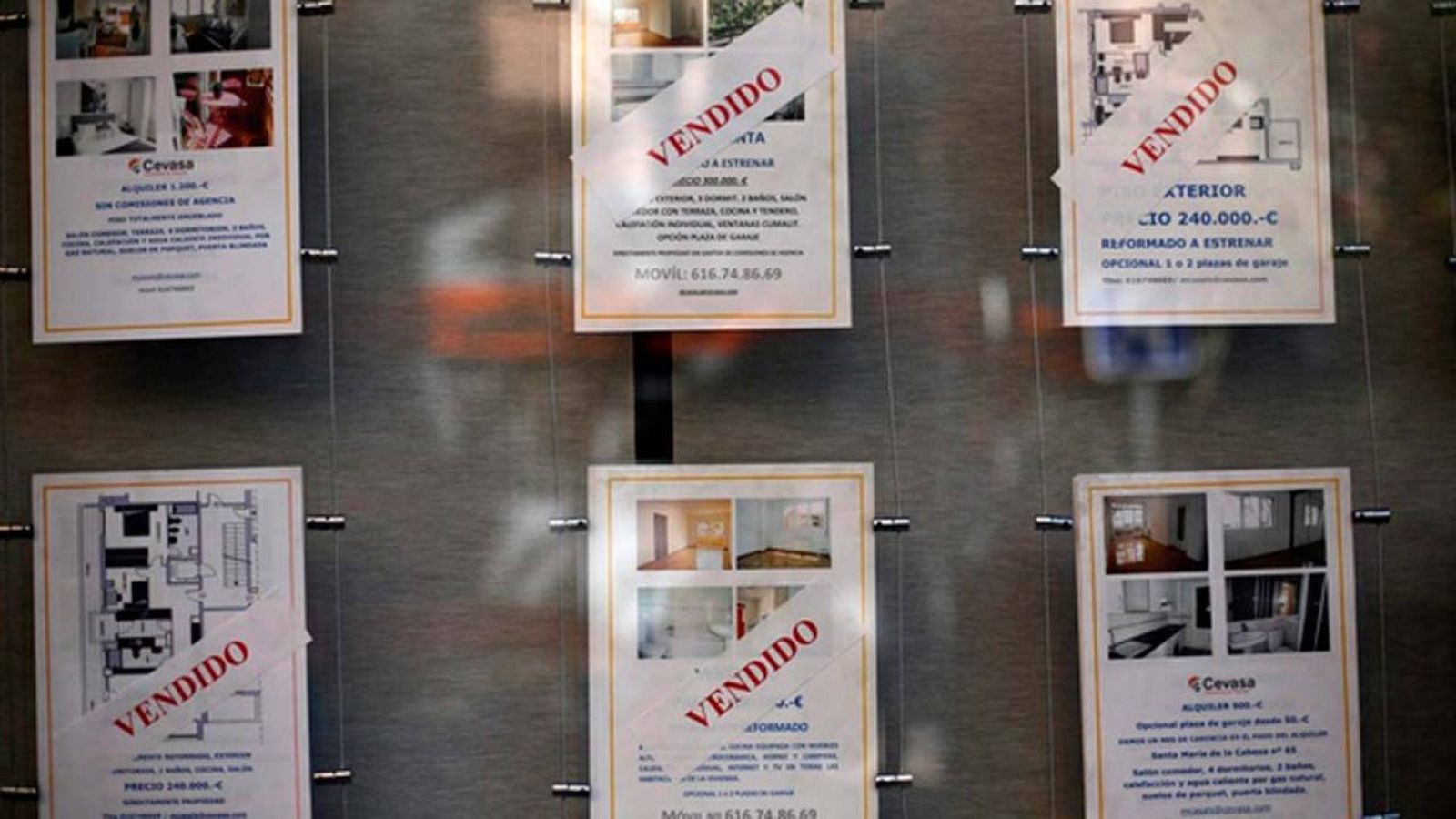 Anuncios de viviendas en el escaparate de una inmobiliaria