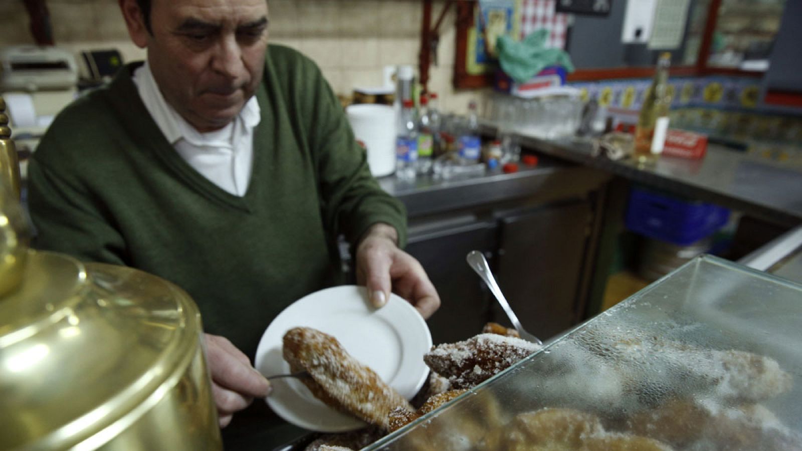 Un hombre sirve unas torrijas en un bar